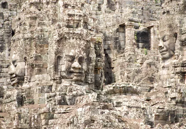 Giant brick sculptures of faces built into the side of a wall.  Angkor Wat maybe.