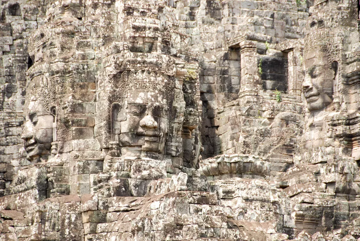 Giant brick sculptures of faces built into the side of a wall.  Angkor Wat maybe.